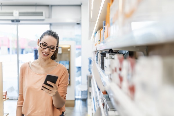 Woman in a pharmacy using her phone