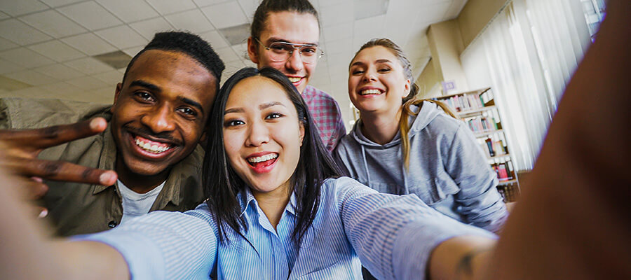 A group of students smiling in a library