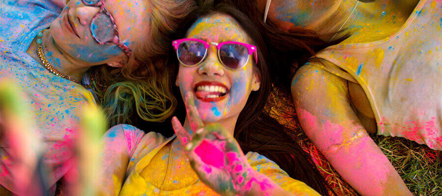 A student smiling, covered in paint